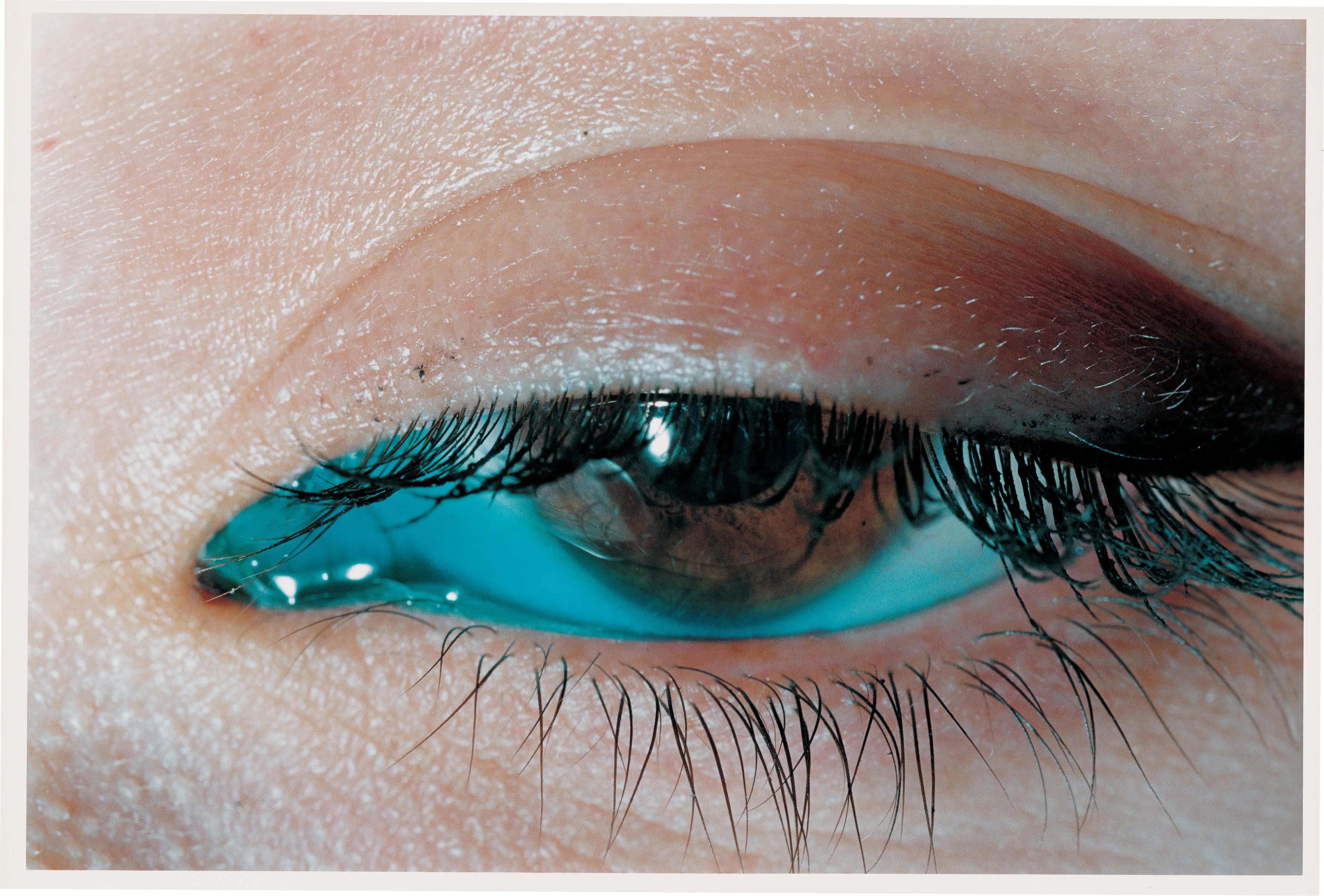 Close up photo of a human eye partially closed by Elinor Carucci