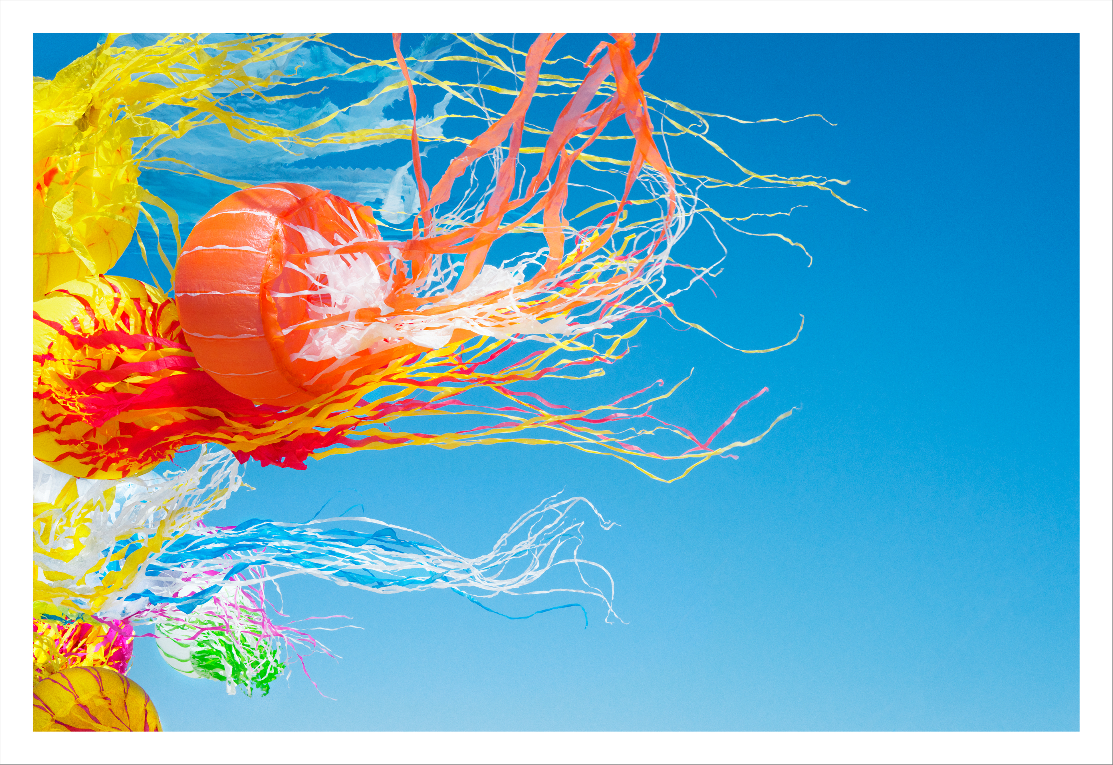 Colorful jellyfish kites made of plastic blow through the air. 